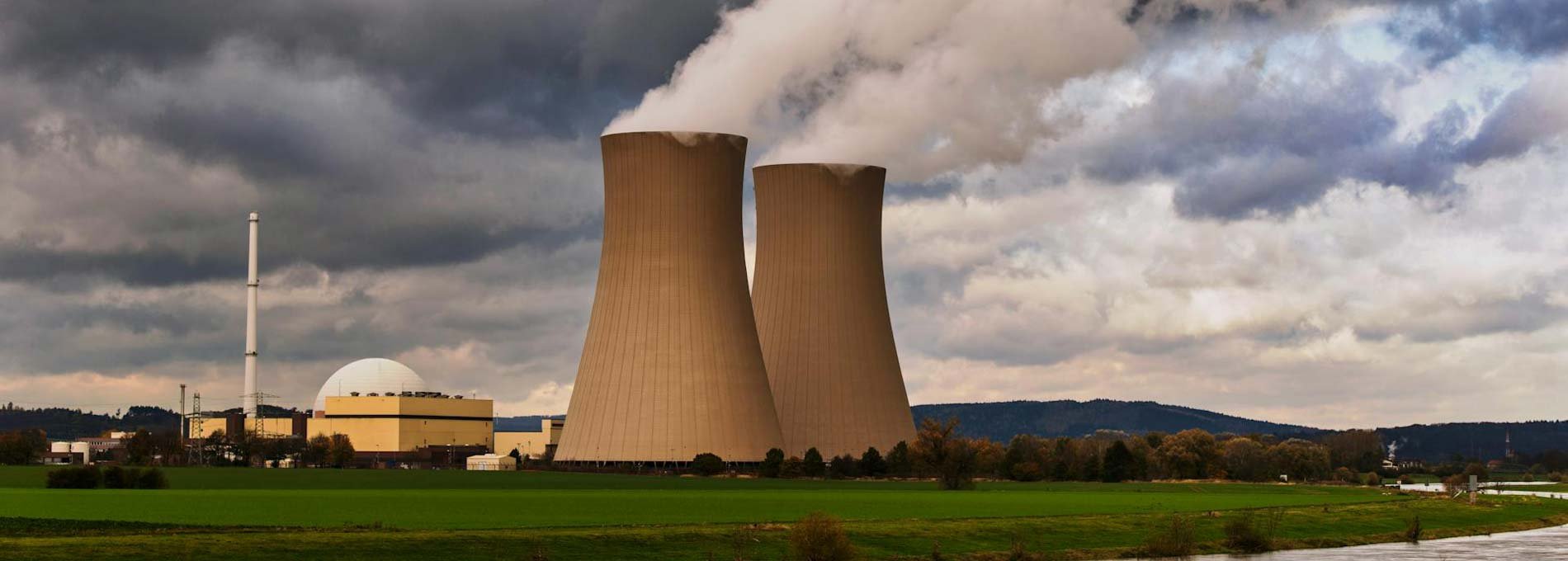 Ein Atomkraftwerk mit charakteristischen Kuppel in einer flachen Landschaft.