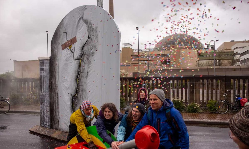 Foto: Aktion vor dem AKW Emsland mit einem AKW-Modell und einem großen Aus-Schalter