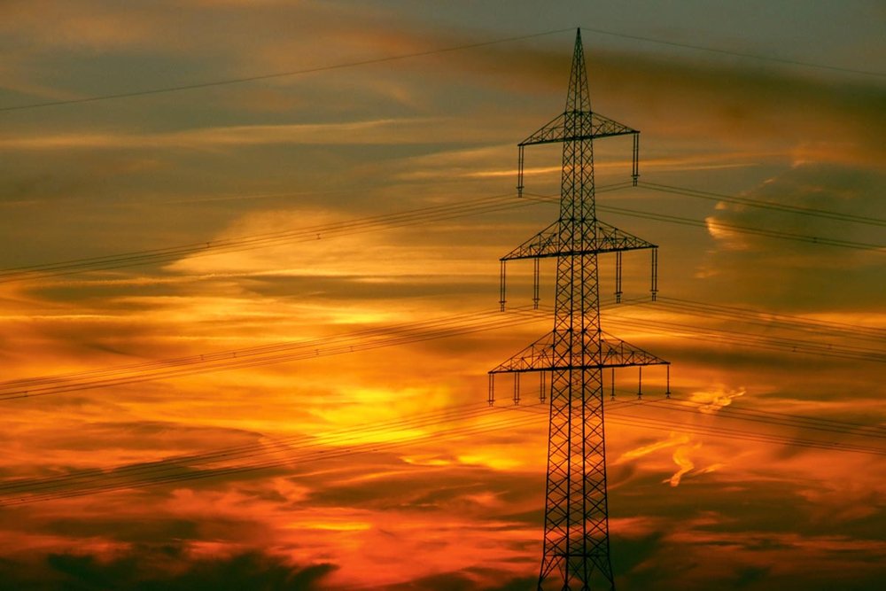 Foto: ein Strommast vor einem Sonnenuntergang