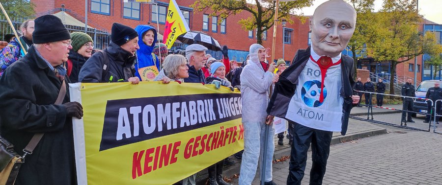 Foto: Proteste beim Eröterungstermin in Lingen, Menschen mit Protestbanner und einer Putin-Maske