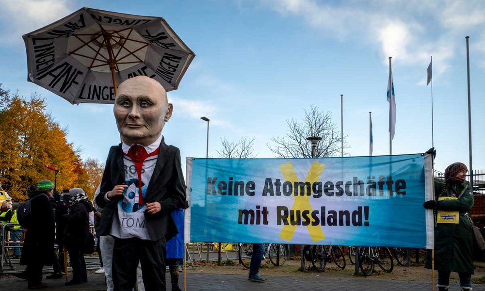Eine lebensgroße Putin-Figur steht neben einem Banner mit der Aufschrift: "Keine Atomgeschäfte mi Russland"