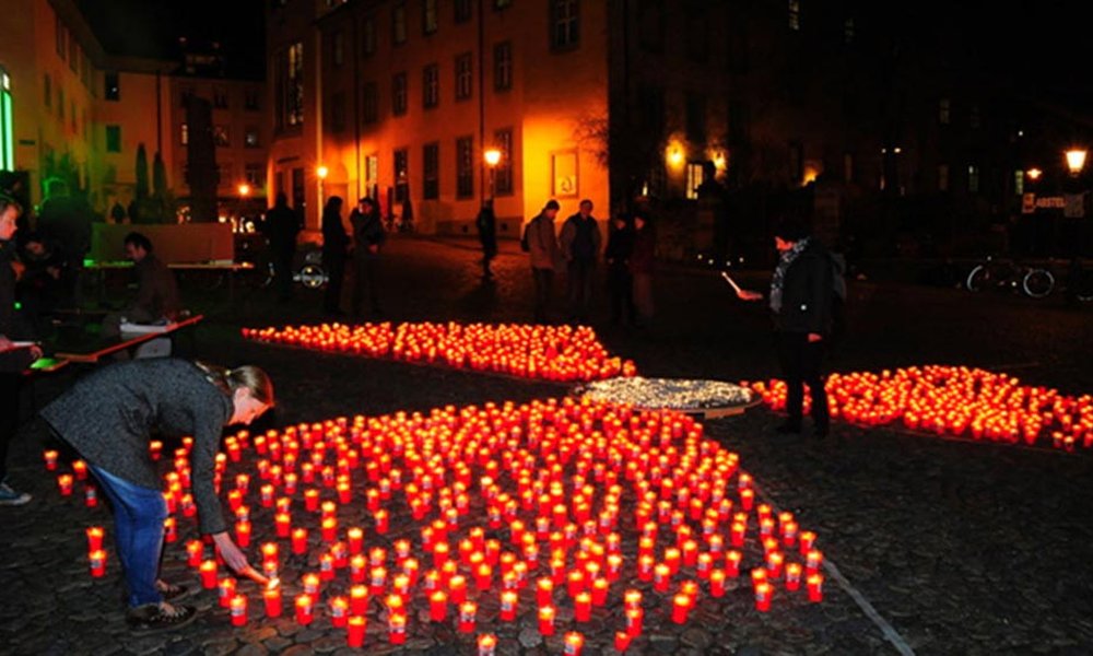 In der Dunkelheit bilden viele Kerzen das Zeichen für Radioaktivität