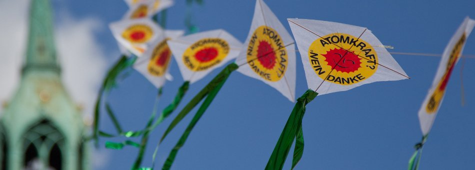 Foto: Papierdrachen mit Anti-Atom-Sonne wehen im Wind vor einem blauen Himmel
