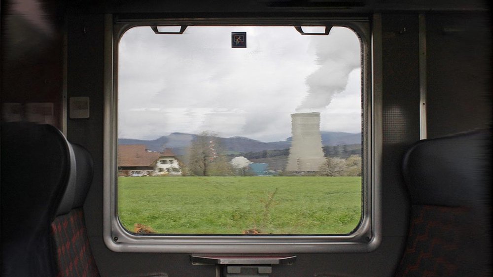 Das verschwommene AKW Gösgen durch die Fensterscheibe einer fahrenden Bahn