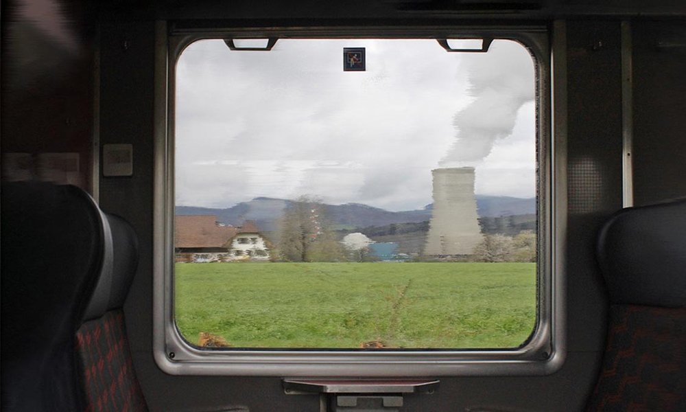 Das verschwommene AKW Gösgen durch die Fensterscheibe einer fahrenden Bahn