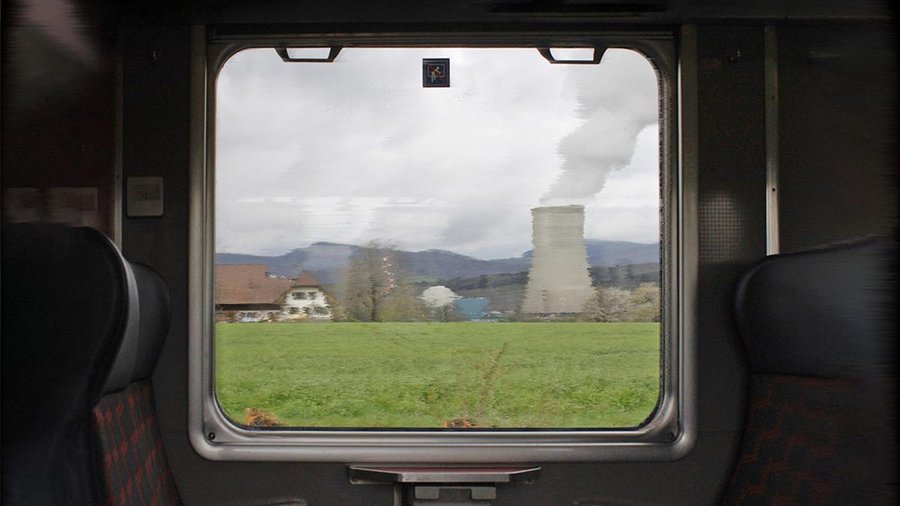 Das verschwommene AKW Gösgen durch die Fensterscheibe einer fahrenden Bahn