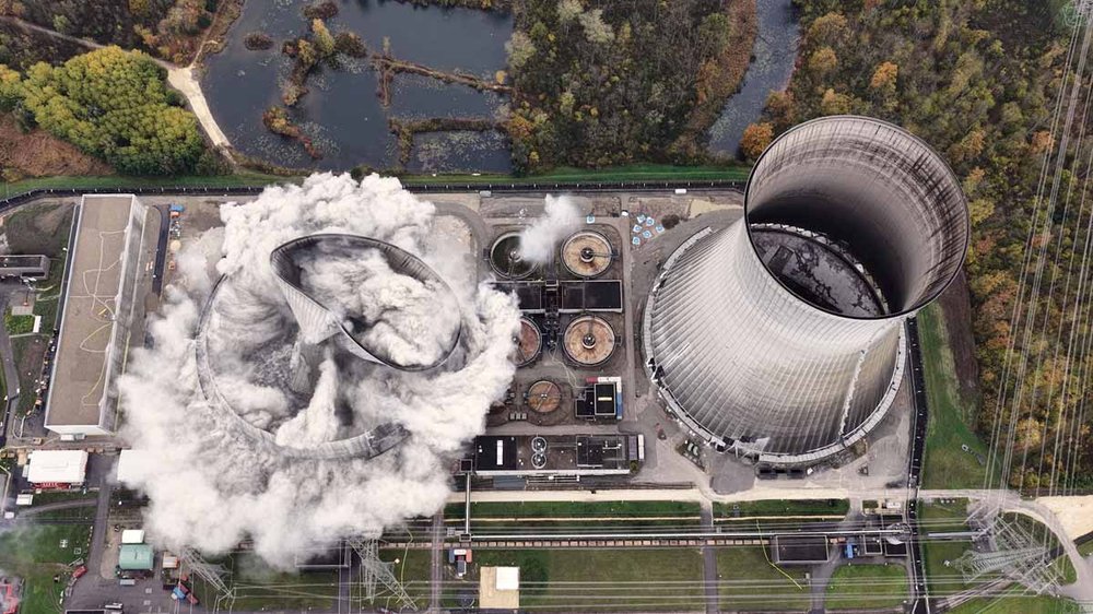 Ein Bild aus der Vogelperspektive zeigt die Sprengung eines Kühlturms eines Atomkraftwerks