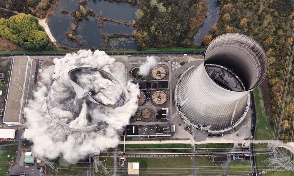 Ein Bild aus der Vogelperspektive zeigt die Sprengung eines Kühlturms eines Atomkraftwerks
