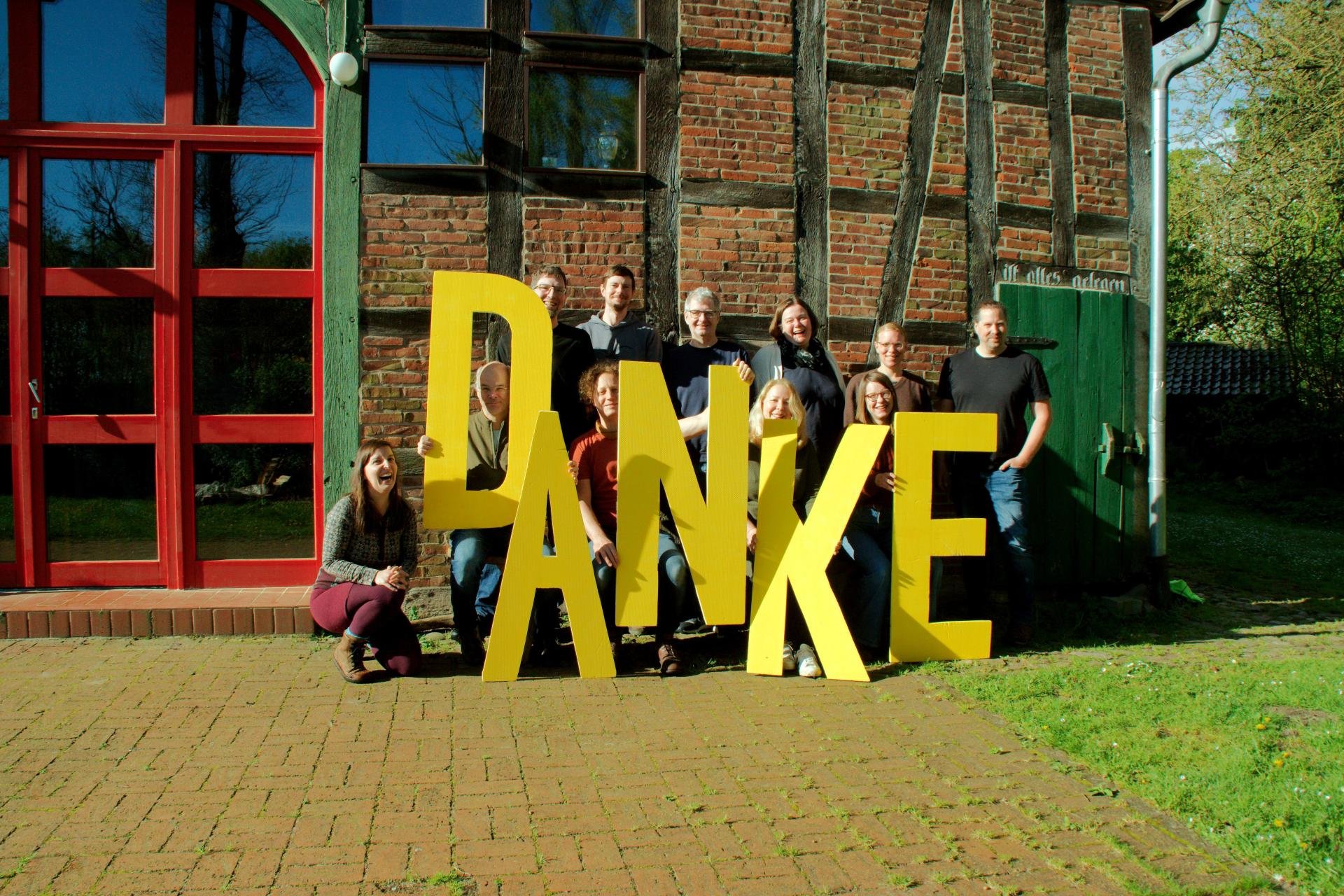 Foto: Das ausgestrahlt-Team hält große gelbe Buchstaben, die das Wort Danke ergeben
